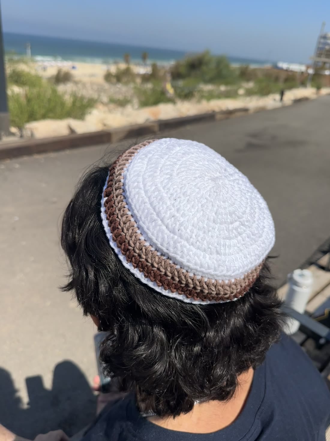 כיפה סרוגה בלבן עם פס בורדו וחום, מעבודתה של מורן